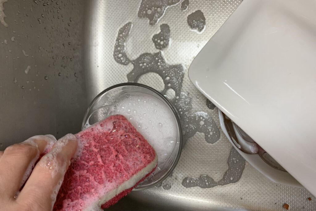 洗いもので、コップに入れた洗剤液を使っている様子