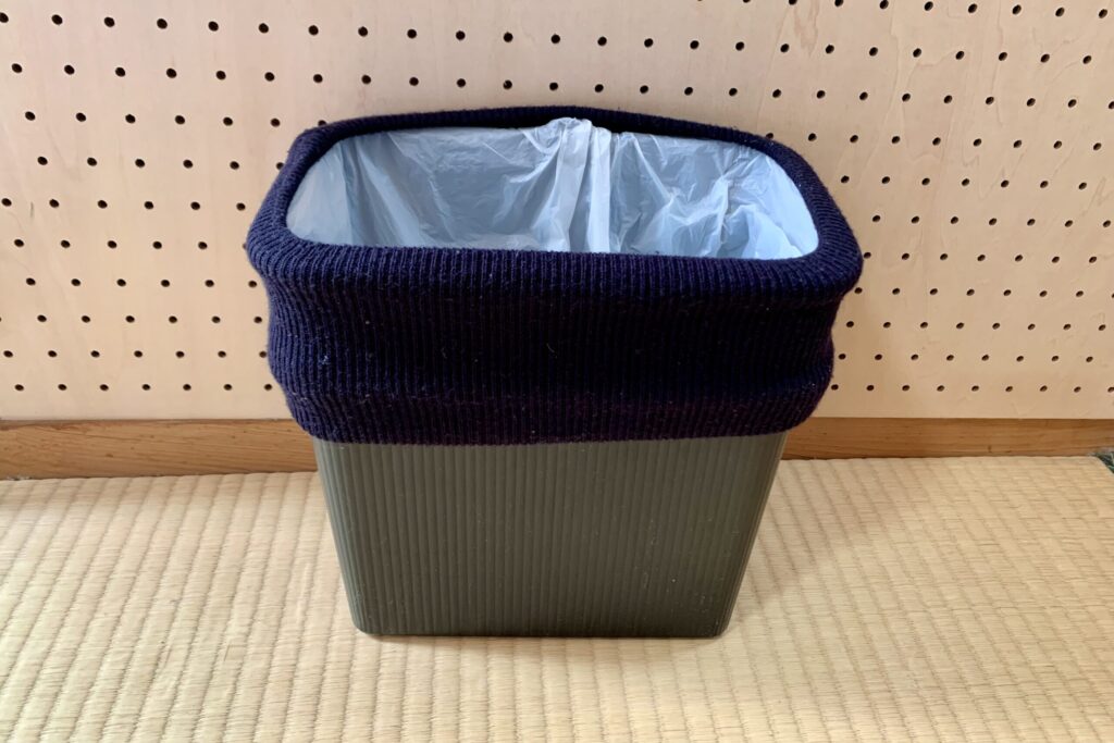 ネックウォーマーを付けたゴミ箱